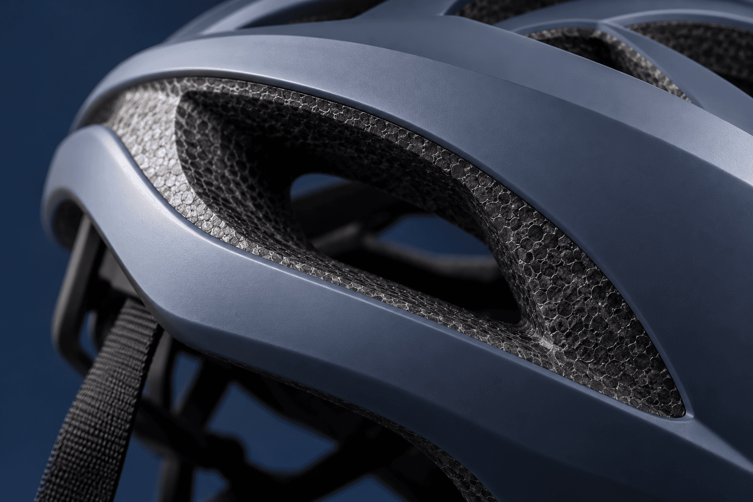 Redaktionelle Illustration: Nahansicht eines Fahrradhelms mit sichtbarer Grenze zwischen Außenschale und Schaumstoff im Bereich einer Lüftungsöffnung