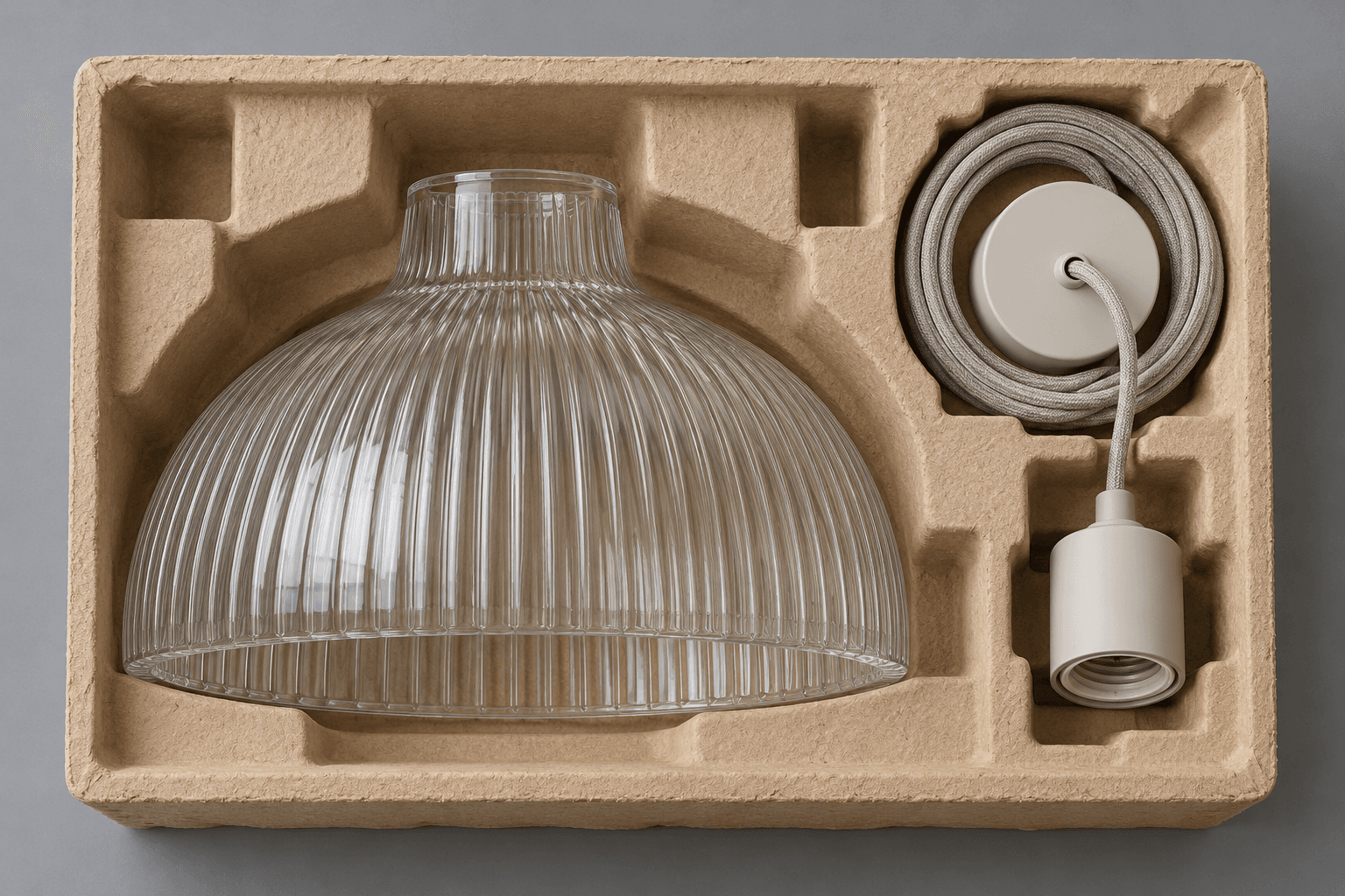 Editorial illustration: a glass pendant shade and separate cord and socket components sit in individual moulded-pulp packaging cavities